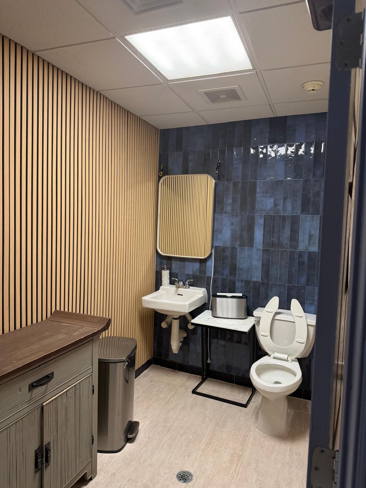 Renovated restaurant restroom with wood slat and blue tile wall finishes