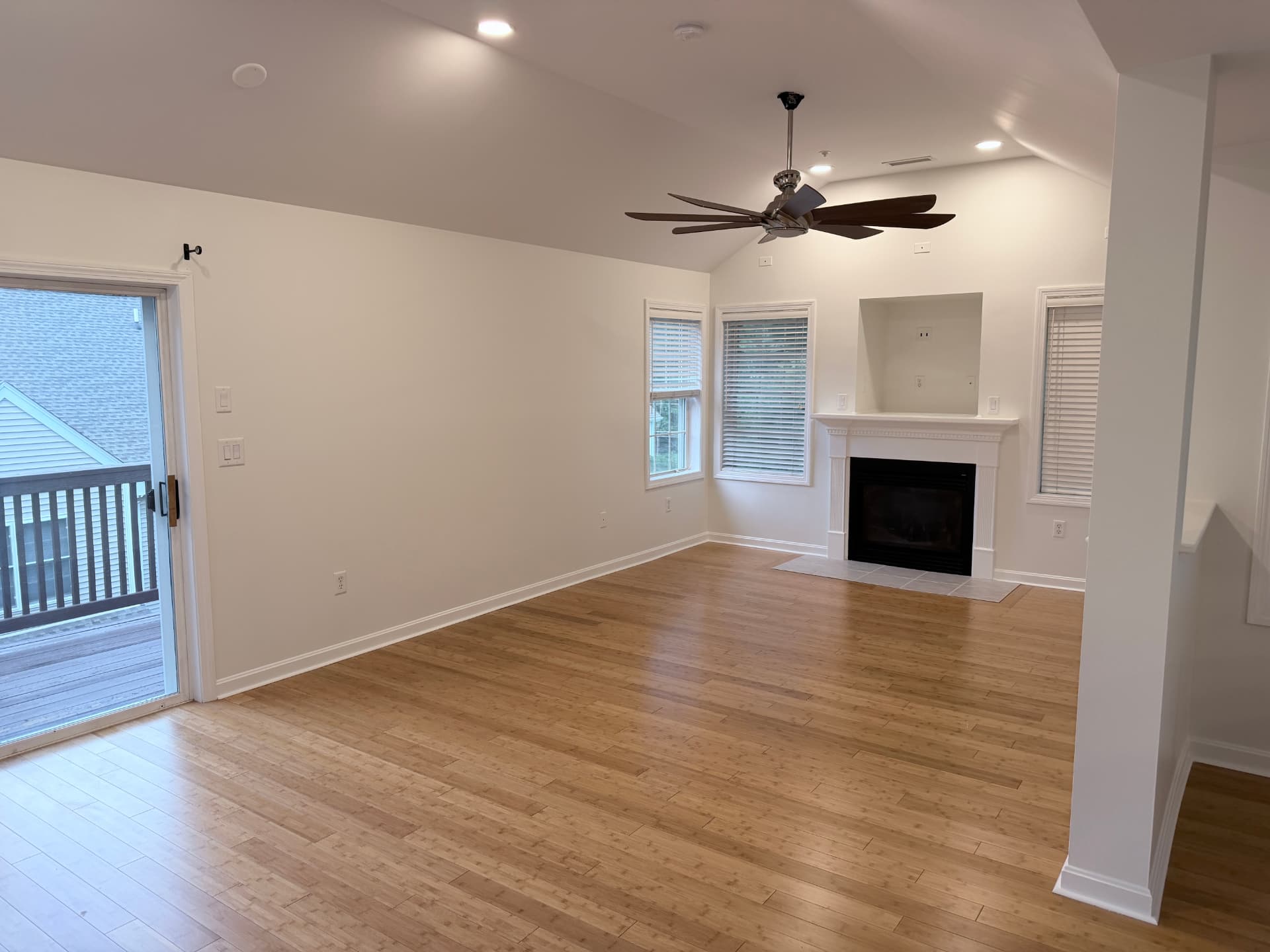 Repainted living room with fireplace, vaulted ceiling and hardwood floors