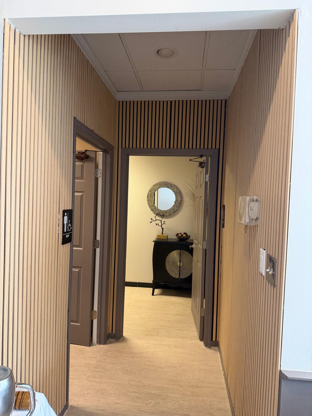 Renovated restaurant hallway with vertical wood slat wall finish