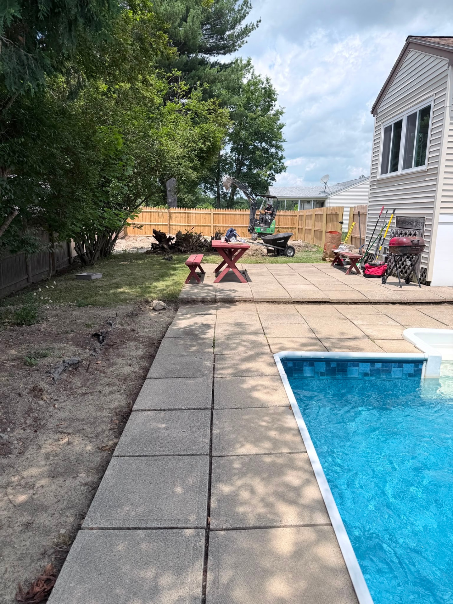 Backyard renovation work in progress beside the pool and patio
